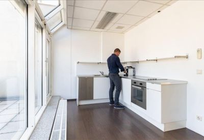 Clean, white minimalist kitchen and breakout area with modern appliances.