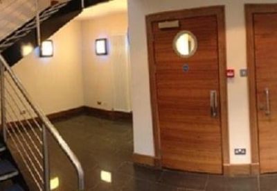 Modern lobby area featuring a sleek staircase with metal railings and wooden doors.