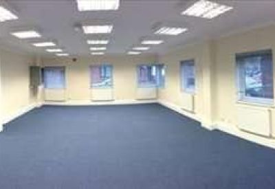 Wide-angle view of a vacant office suite showing white walls and a large pillar.