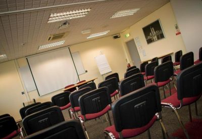 Spacious presentation room with rows of chairs and a projection screen.
