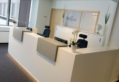 Modern white reception desk with minimalist branding and orchid plants.