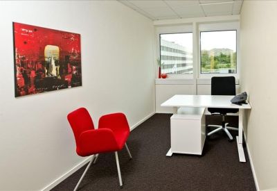 Private office for one featuring a red armchair and white desk.