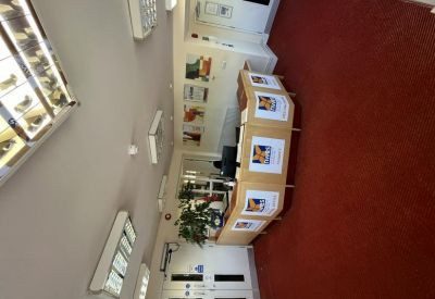 Professional reception area with a wooden front desk and red carpeting.