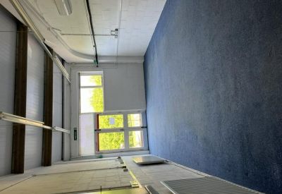 Large industrial-style workspace with blue carpet and exposed ceiling beams.