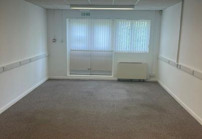 Bright, empty office suite with carpeted floors and fluorescent lighting.