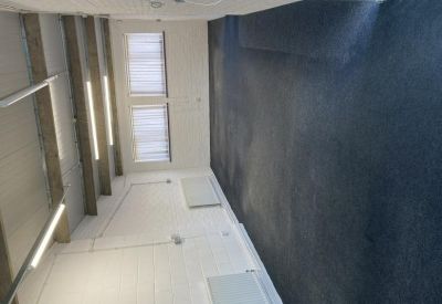 Spacious office interior with dark grey carpeting and large windows.