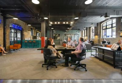 Spacious communal lounge and coworking area with modern industrial styling.