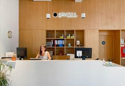 Bright reception desk with minimalist wood paneling and branded signage.