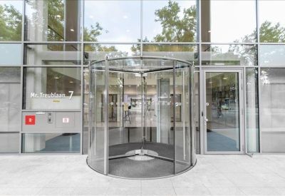Close-up of a glass revolving door entrance and secondary side door.