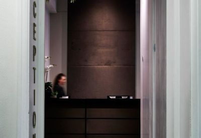 Reception area viewed through a doorway with dark wood panelling and a front desk.