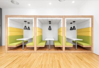 Semi-private acoustic seating booths with vibrant green and yellow upholstery.
