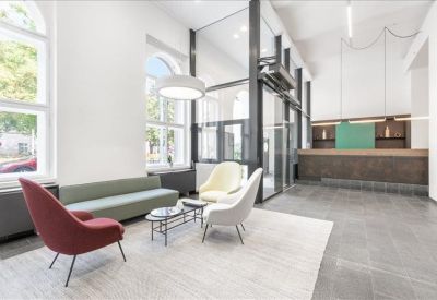 Bright lobby area with a mix of lounge seating and a service counter.