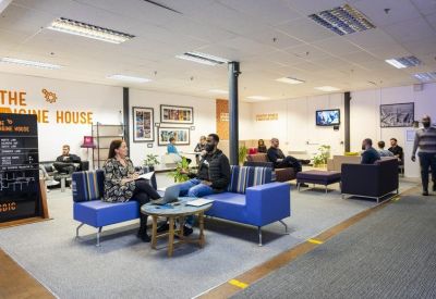 Spacious communal lounge area with blue sofas, coffee tables, and casual seating.