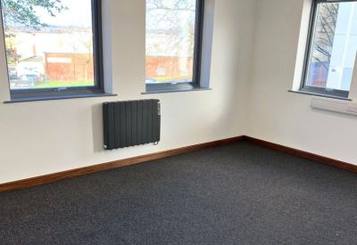 Private office space featuring three large windows and a modern black radiator.