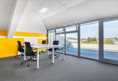 Office space with a bold yellow feature wall and large glass doors leading to a terrace.