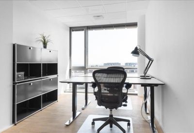 Bright private office suite with a sit-stand desk and natural light.