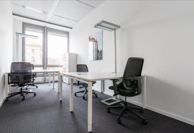 Minimalist private office with white desks and black mesh chairs.