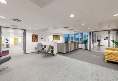 Spacious reception area featuring a grey front desk and a bright yellow tufted sofa.