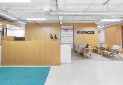 Reception area with a light wood desk, branded signage, and comfortable lounge seating.