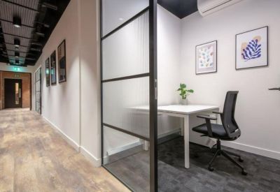Private one-person office suite with a white desk and frosted glass partition.