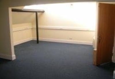 Brightly lit corner office with vaulted ceilings and timber support posts.