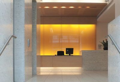 Modern lobby area with marble stairs and a glowing yellow reception backdrop.