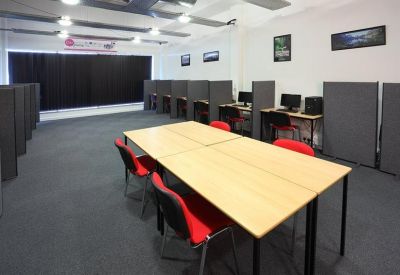 Spacious office workspace with partitioned computer workstations and a central collaborative table.