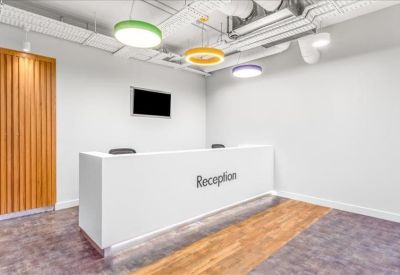 Sleek white reception desk with modern pendant lighting and wood-style flooring.