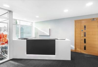Minimalist reception area with a sleek white and black desk and wooden door.