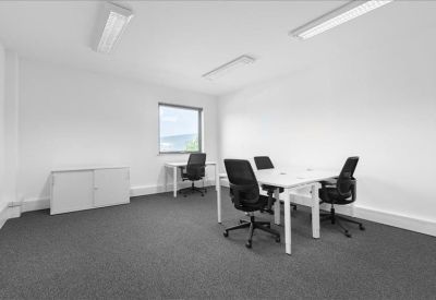 Clean white private office space with three black ergonomic chairs and white desks.