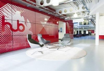 Branded reception area with red graphic walls and stylish grey lounge chairs.