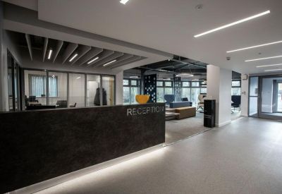Sleek reception area with a dark textured desk and modern linear lighting.