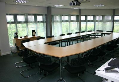 Large conference room with a U-shaped table setup and floor-to-ceiling windows.