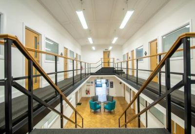 Bright multi-level atrium with a central staircase and upper-floor walkways.