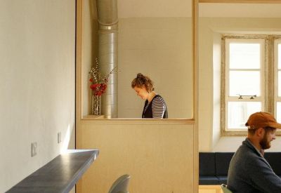 Breakout area with a blue breakfast bar and light wood partitions.