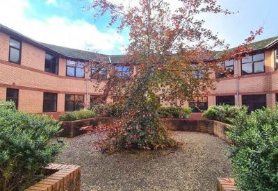 Landscaped internal courtyard with a central tree surrounded by the brick office building.