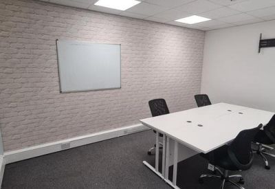 Private four-person meeting room with a textured feature wall and a white conference table.