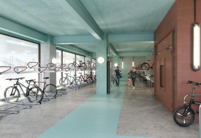 Indoor bicycle storage facility with teal painted beams and wall-mounted racks.