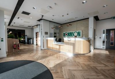 Spacious reception area with wooden parquet flooring and a curved service desk.
