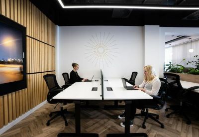 Bright coworking space with white desks and a wood-slatted feature wall.