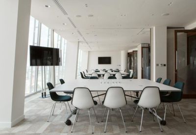 Bright, modern meeting room with large white conference tables and city views.