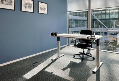 Bright collaborative space with a large table, black chairs, and a red privacy booth.