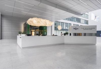 Expansive white reception desk under a large, cloud-like pendant light fixture.