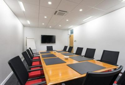 Professional meeting room featuring a large wooden table and black ergonomic chairs.