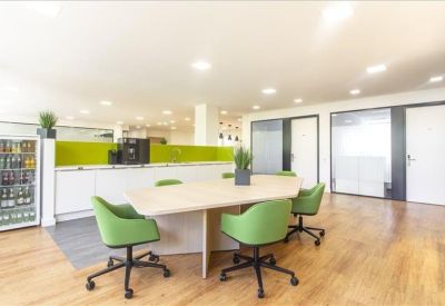 Casual breakout area with lime green chairs and white storage cupboards.