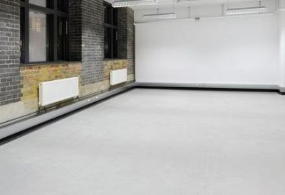 Empty white-walled office space with exposed brick accents and natural light.