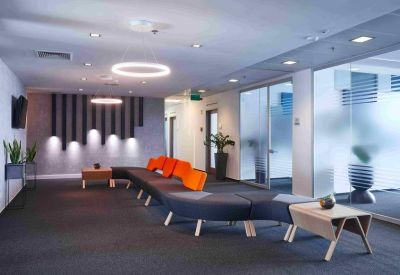 Lounge area featuring a long curved sofa with vibrant orange backrests.