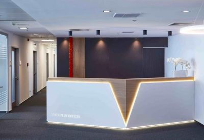 Modern reception desk with backlit chevron design and dark wood accents.