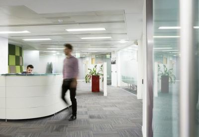 Bright, modern reception area with a curved white desk and glass partitions.