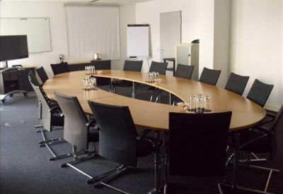 Professional meeting room with a large oval table and seating for twelve people.